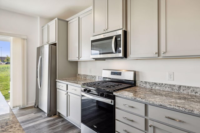 kitchen featuring stainless steel appliances, light stone countertops, and light hardwood / wood-style floors