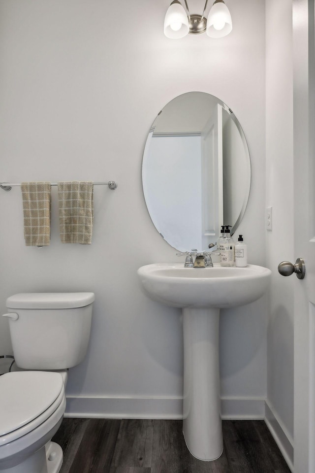 bathroom with hardwood / wood-style flooring and toilet