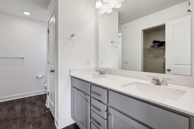 bathroom featuring vanity, wood-type flooring, and toilet