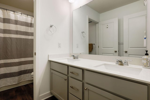 bathroom with hardwood / wood-style flooring, vanity, and toilet