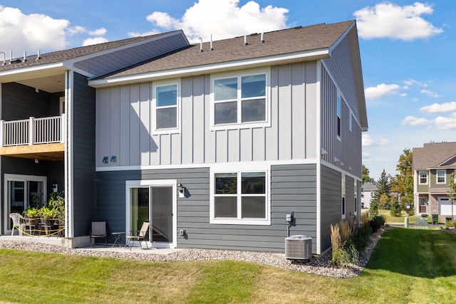 rear view of house featuring a lawn, central AC unit, and a patio area