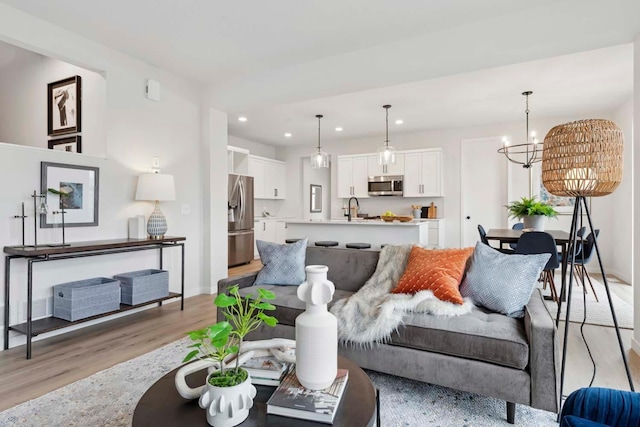 living room featuring a chandelier and light wood-type flooring