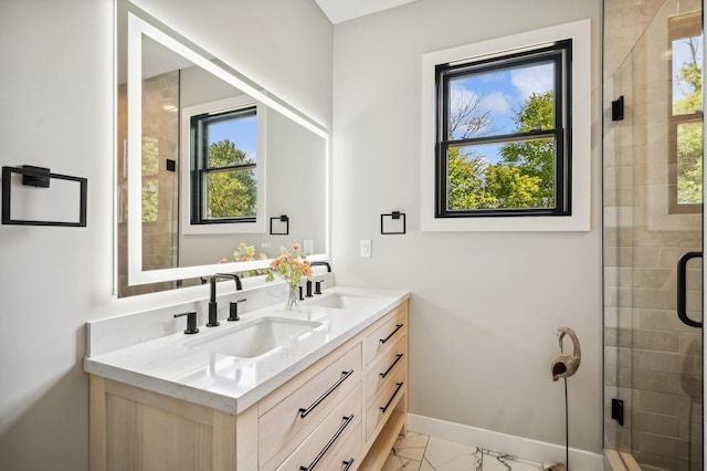 bathroom featuring baseboards, double vanity, a stall shower, marble finish floor, and a sink