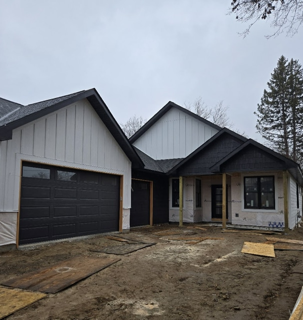 view of front of home featuring an attached garage and roof with shingles