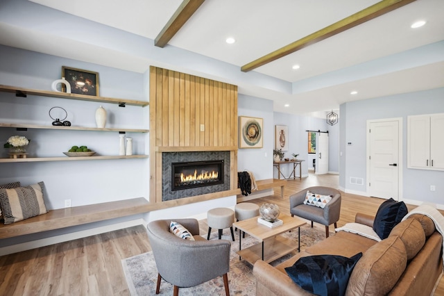living area featuring light wood-style floors, beam ceiling, and recessed lighting
