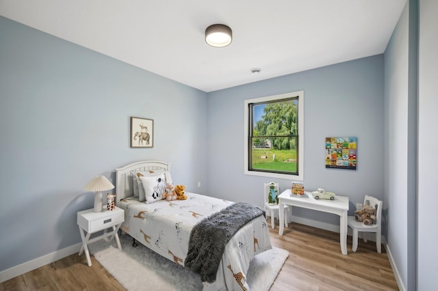 bedroom with light wood-style floors and baseboards