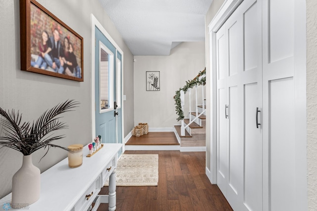 interior space with a textured ceiling and dark hardwood / wood-style floors