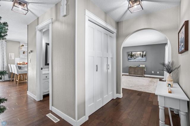 hallway featuring a textured ceiling and dark hardwood / wood-style floors