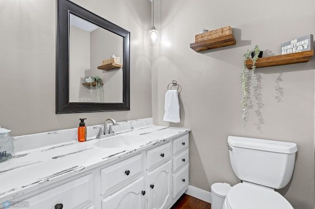 bathroom featuring toilet, vanity, and hardwood / wood-style flooring