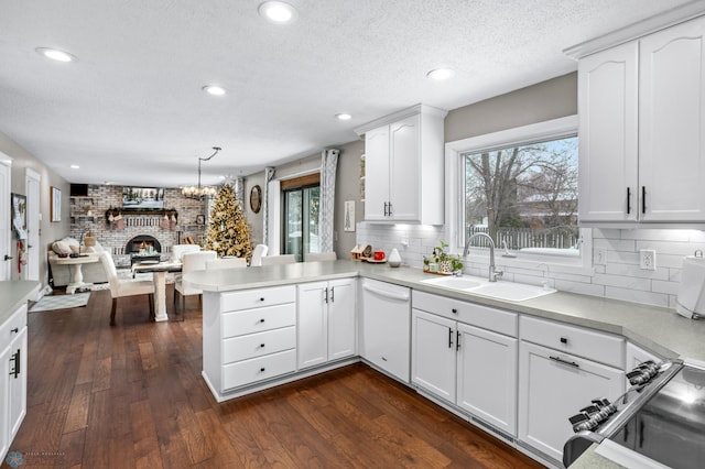 kitchen with kitchen peninsula, decorative light fixtures, dishwasher, white cabinets, and dark hardwood / wood-style floors