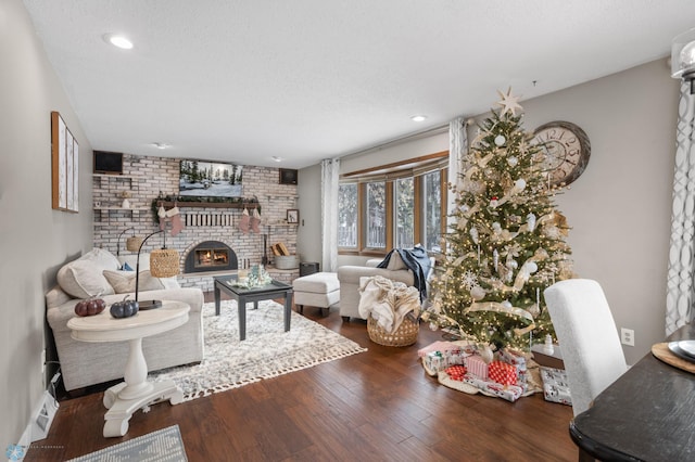 living room featuring hardwood / wood-style flooring, a fireplace, and a textured ceiling