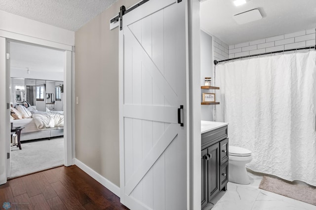 bathroom with a textured ceiling, vanity, hardwood / wood-style flooring, and toilet