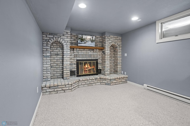 unfurnished living room with carpet flooring, baseboard heating, and a brick fireplace