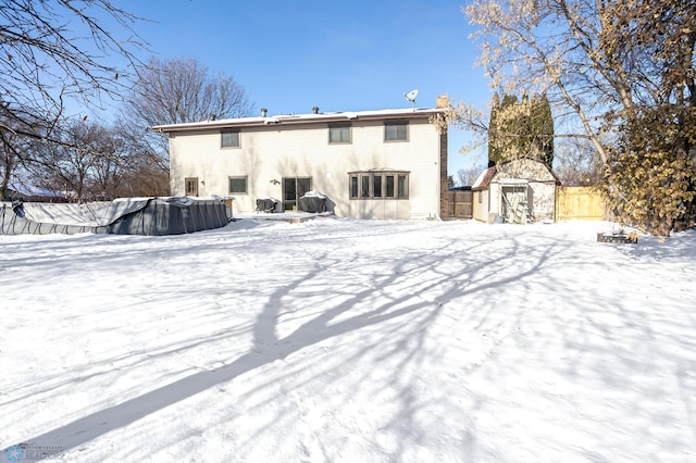 snow covered house with a storage shed