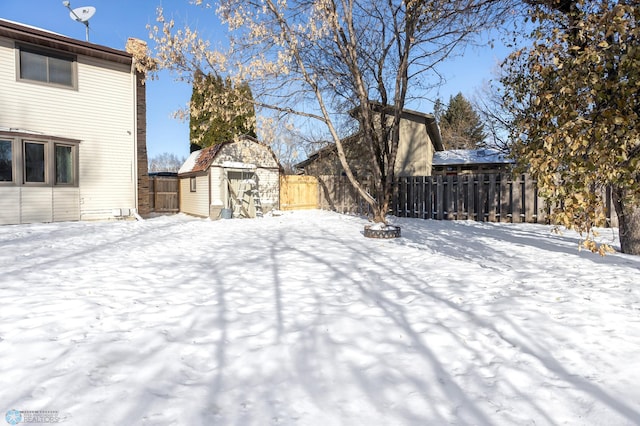 yard layered in snow with a storage unit