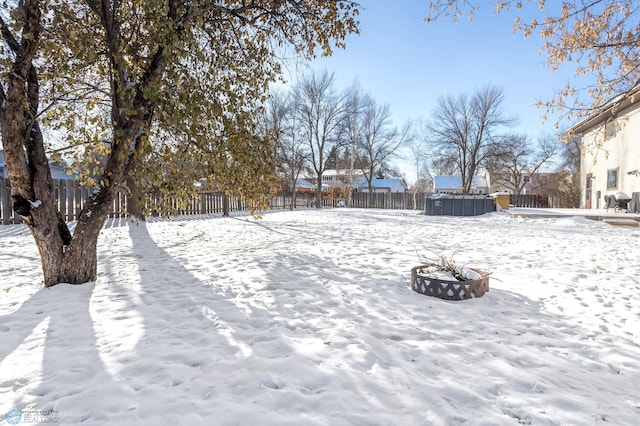 yard layered in snow with an outdoor fire pit