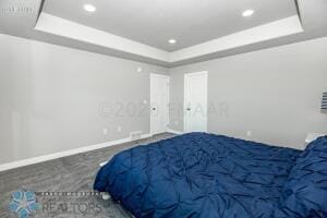 bedroom with a raised ceiling and carpet