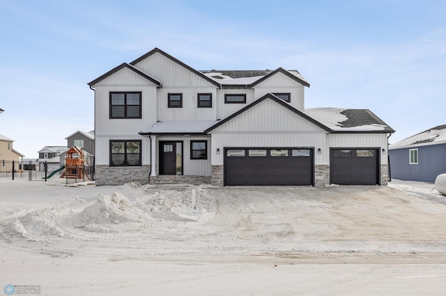 modern farmhouse with a garage, stone siding, a playground, and fence