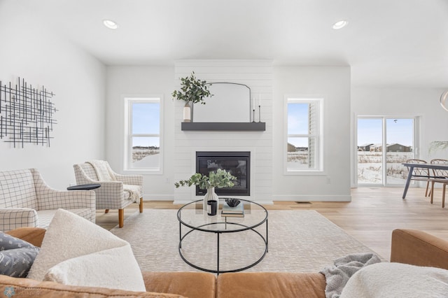 living room with wood finished floors, a fireplace, and recessed lighting