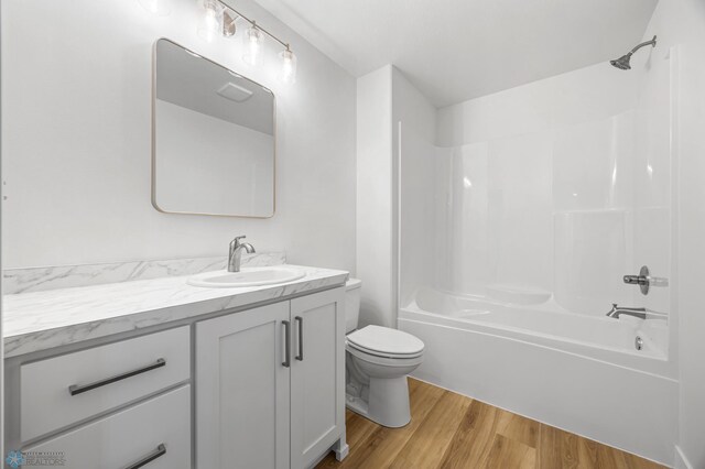 full bath featuring shower / bath combination, wood finished floors, toilet, and vanity