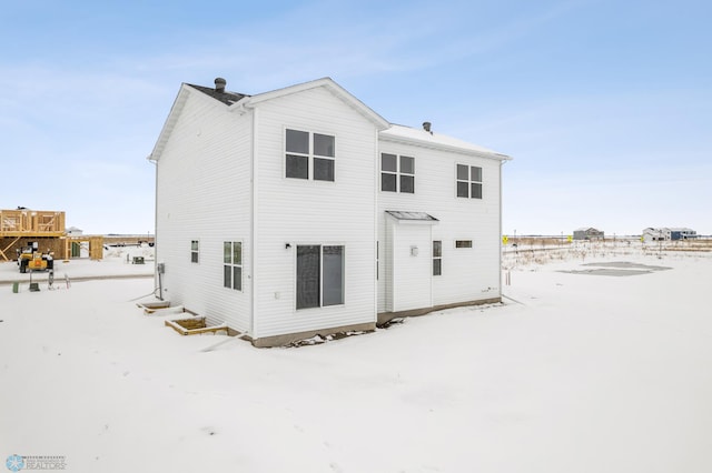 view of snow covered back of property