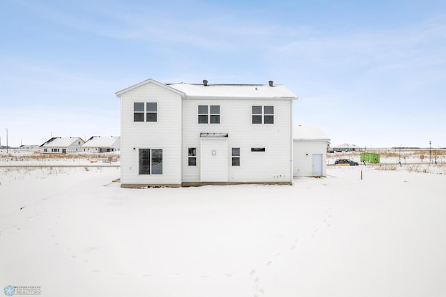 view of snow covered back of property