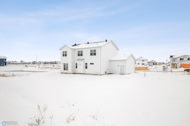 view of snow covered rear of property