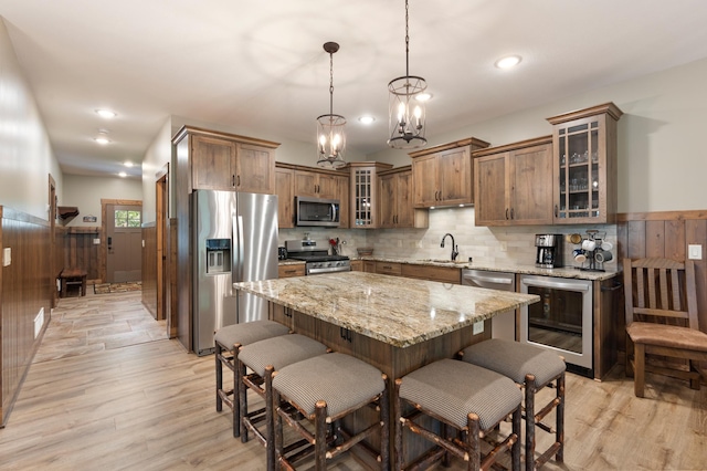 kitchen with a chandelier, light hardwood / wood-style flooring, stainless steel appliances, and decorative light fixtures