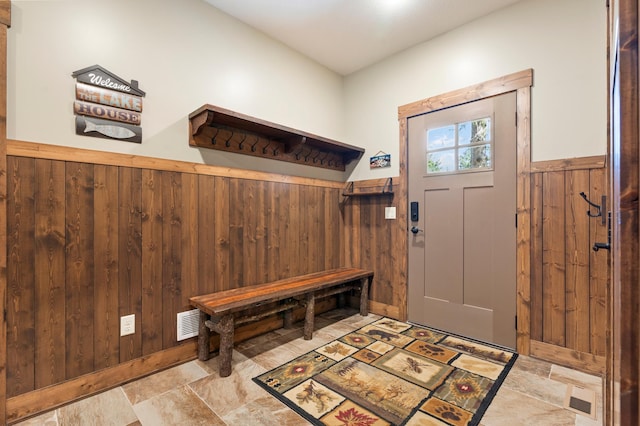 mudroom featuring wood walls