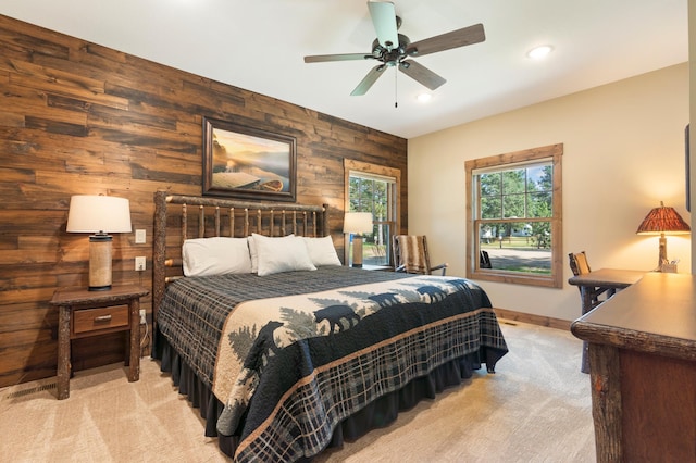 carpeted bedroom with ceiling fan and wooden walls