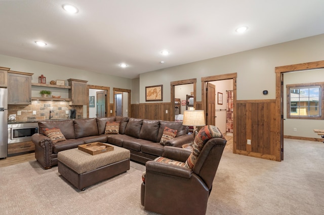 living room with light colored carpet and sink