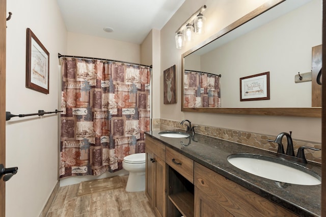 bathroom with vanity, toilet, hardwood / wood-style floors, and walk in shower