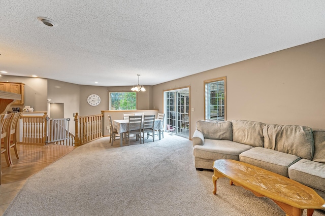 carpeted living room with a notable chandelier and a textured ceiling