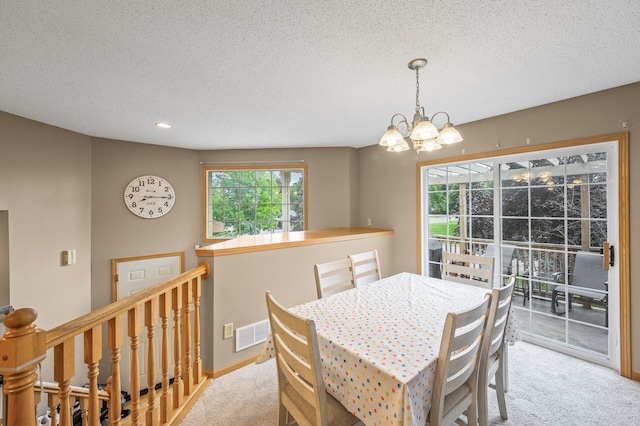 dining area featuring light carpet, an inviting chandelier, and a textured ceiling