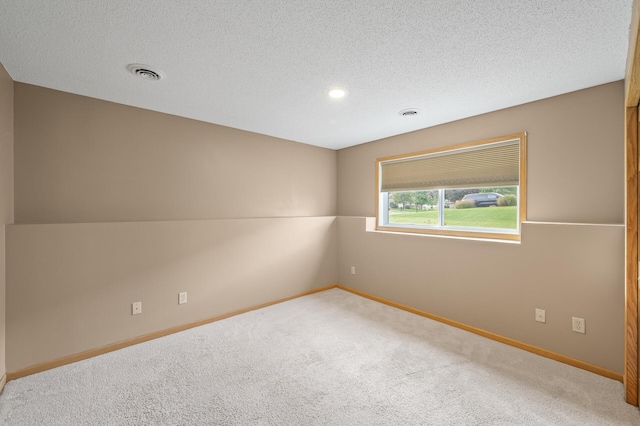 spare room with a textured ceiling and carpet