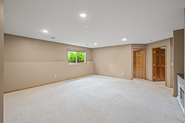 interior space featuring light colored carpet and a textured ceiling