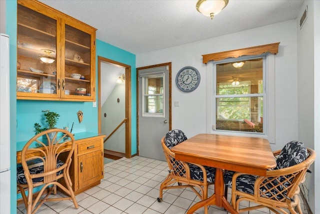 tiled dining room with a textured ceiling