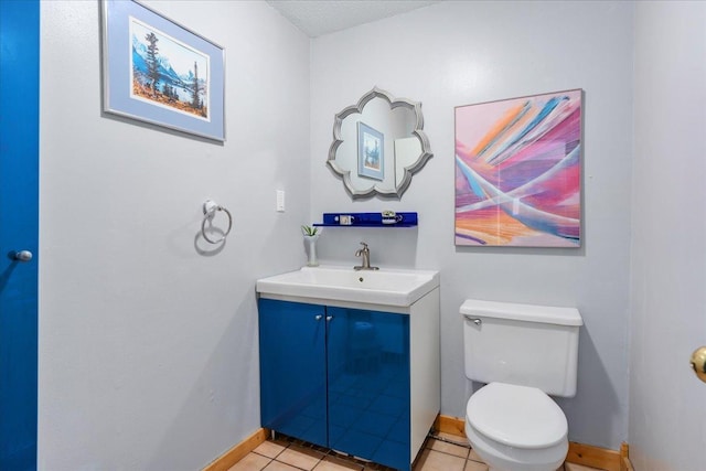 bathroom with vanity, a textured ceiling, tile patterned floors, and toilet