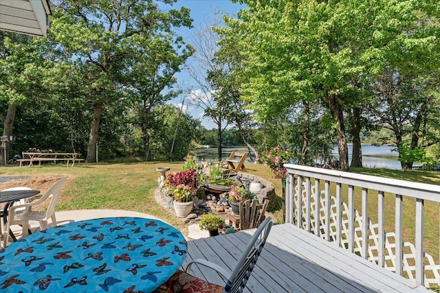 wooden terrace featuring a water view and a yard