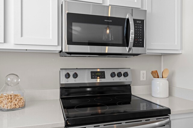 kitchen with stainless steel appliances and white cabinetry