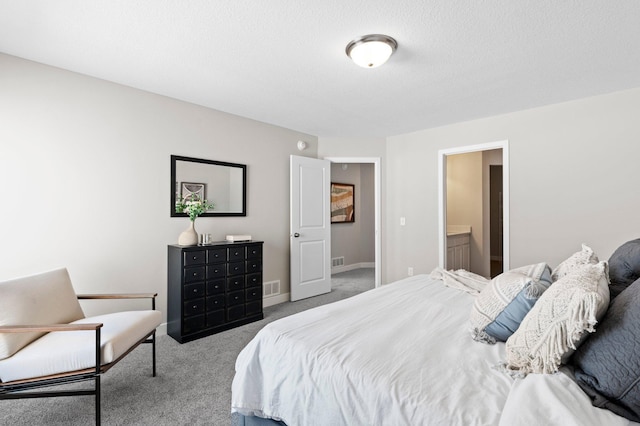 bedroom featuring a textured ceiling, carpet, and ensuite bathroom