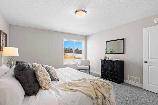 bedroom with light colored carpet and a textured ceiling