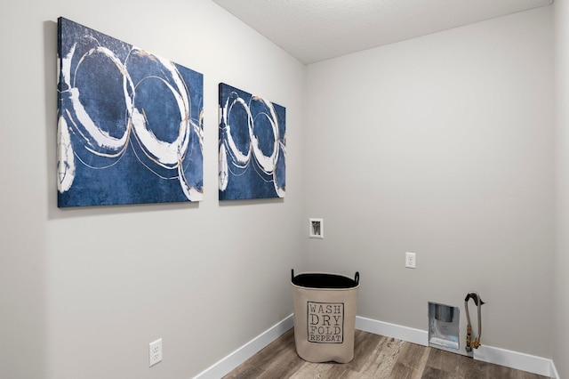 laundry area featuring washer hookup, wood-type flooring, and a textured ceiling