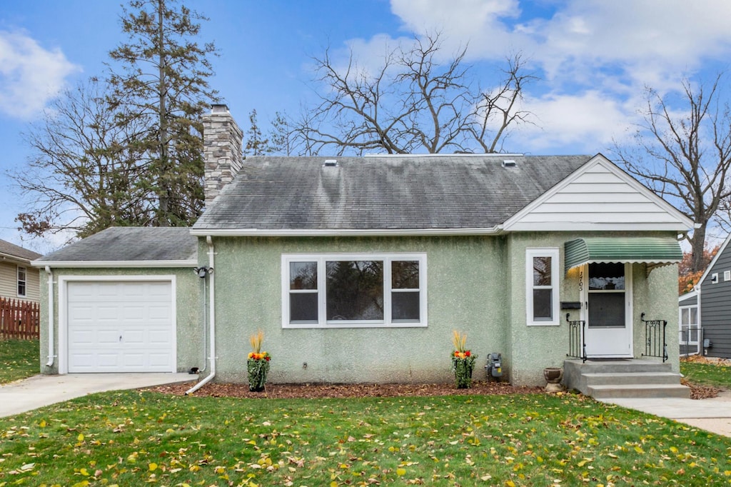 view of front of property featuring a front lawn and a garage