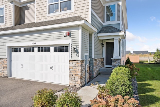 doorway to property featuring a yard and a garage