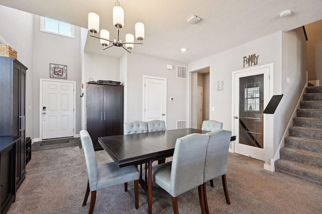 carpeted dining space featuring a textured ceiling and a notable chandelier