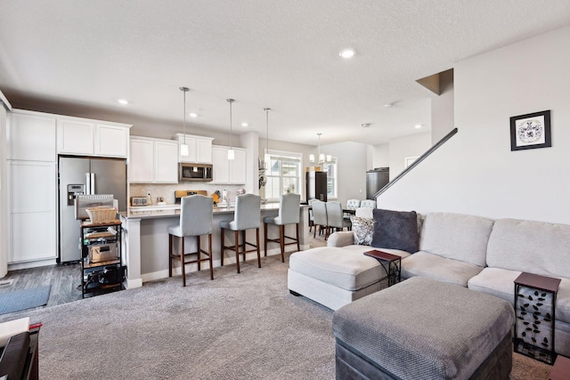 living room featuring hardwood / wood-style floors, a textured ceiling, and an inviting chandelier