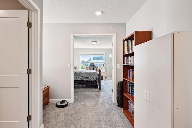 hallway featuring carpet and a textured ceiling