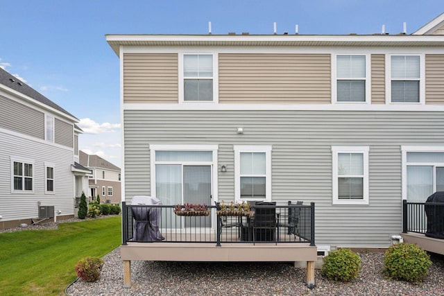 back of house featuring a lawn and a wooden deck