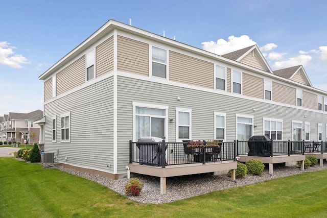 back of house featuring a yard, a deck, and central AC unit